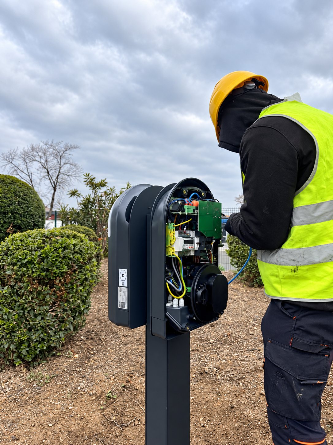 Électricien au travail dans une armoire d'une installation de bornes de recharge
